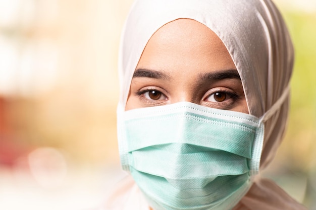 Fille musulmane portant le hijab et un masque chirurgical pour la protection