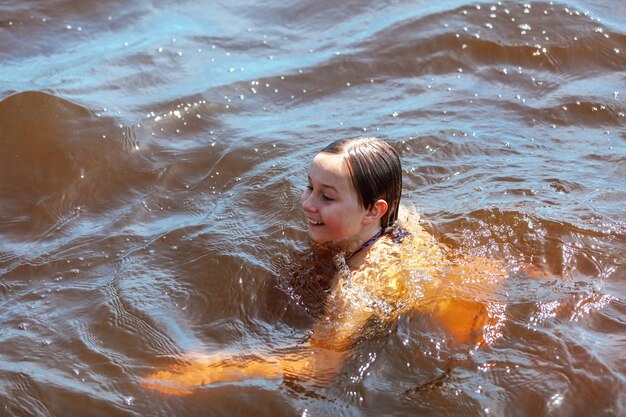 La fille nage dans l'eau