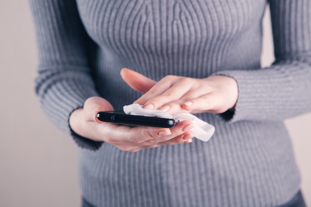 Fille nettoie l'écran du téléphone