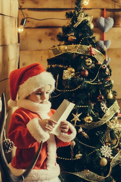 Fille de Noël à l'arbre avec du papier