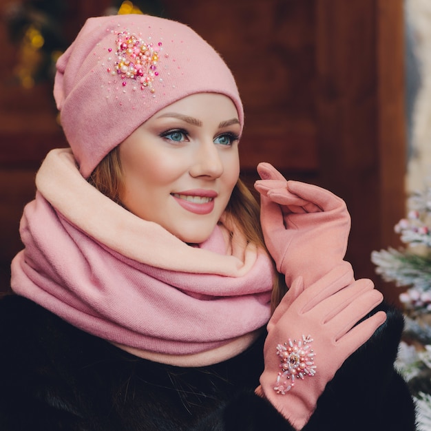 Fille de Noël portant un chapeau chaud et des mitaines, isolé sur gris