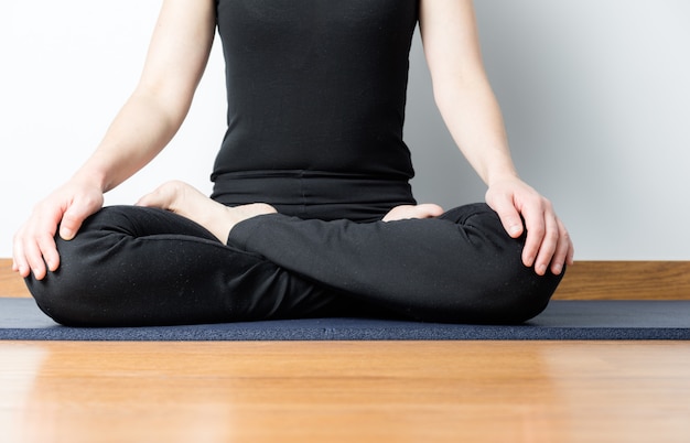 Fille en noir avec posture de yoga