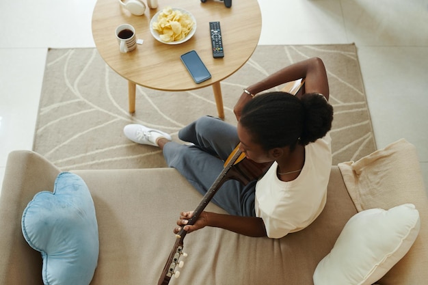 Photo une fille noire jouant de la guitare.