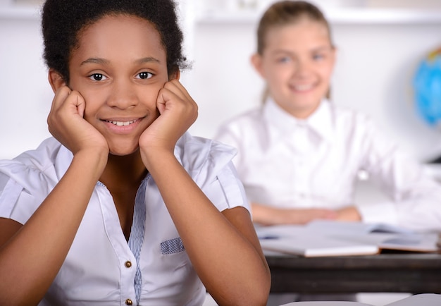 Fille noire souriante en classe à l'école.