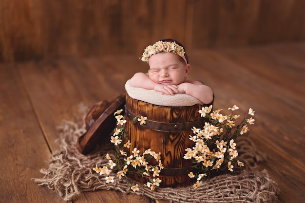 Fille nouveau-née, bébé dort dans un seau de fleurs.