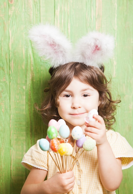 Fille avec des oreilles de lapin et de petits œufs. Fête de Pâques