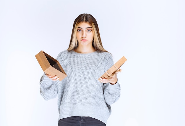 La fille a ouvert une boîte-cadeau en carton et a l'air triste.