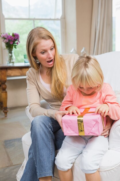 Photo fille ouvrant un cadeau de maman