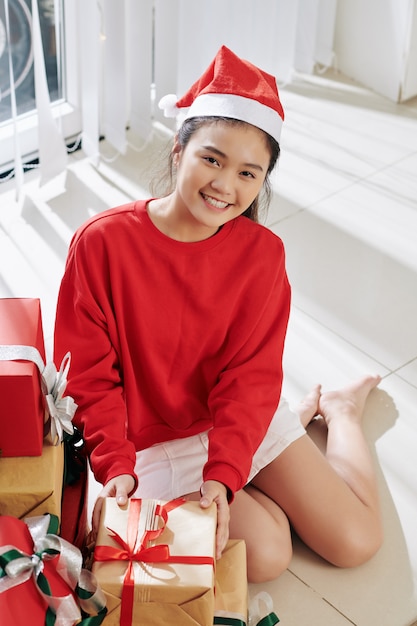 Fille ouvrant des cadeaux de Noël