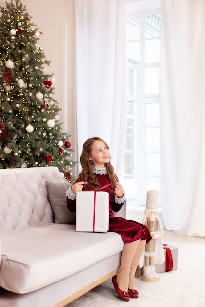 fille ouvre le cadeau de Noël dans le salon