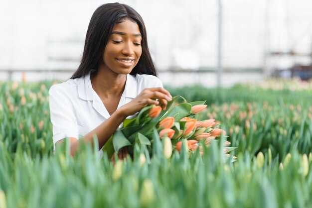 Fille, ouvrière avec des fleurs en serre