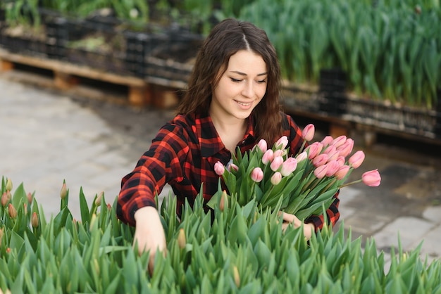 Fille, ouvrière avec des fleurs en serre