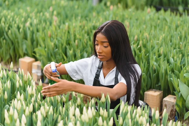 Fille, ouvrière avec des fleurs en serre