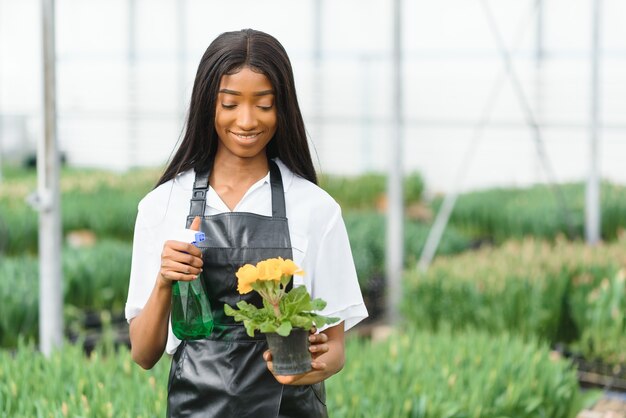 Fille, ouvrière avec des fleurs en serre