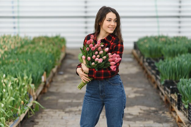 Fille, ouvrière avec des fleurs en serre