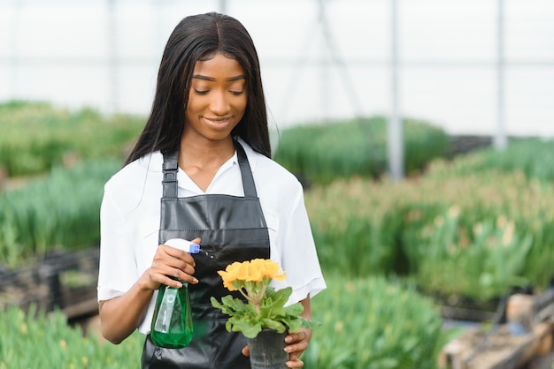 Fille, ouvrière avec des fleurs en serre