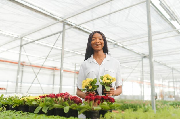 Fille, ouvrière avec des fleurs en serre