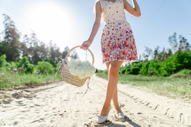 fille avec panier de fleurs en plein air