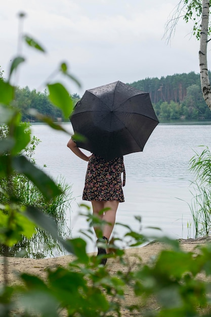 Fille avec un parapluie par temps nuageux