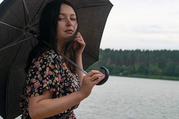 Fille avec un parapluie par temps nuageux