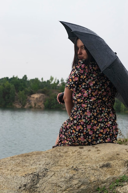 Fille avec un parapluie par temps nuageux