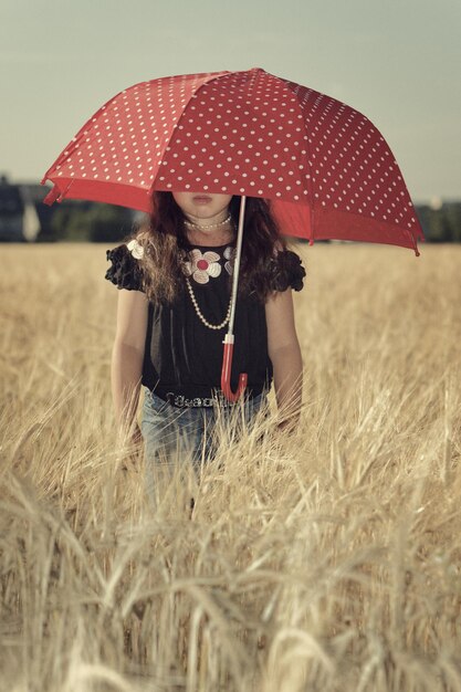 Photo une fille avec un parapluie sur le terrain.