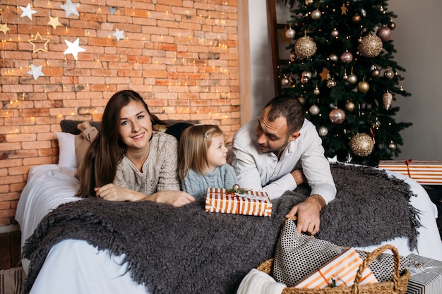 Fille et parents échangeant des cadeaux de Noël