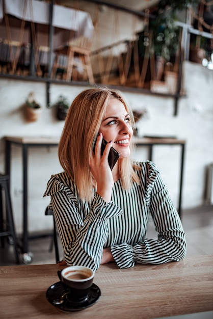 Fille parlant au téléphone mobile à l&#39;intérieur.