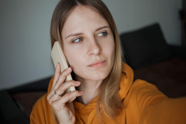 Une fille parle au téléphone et regarde ailleurs