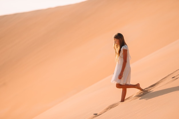 Fille parmi les dunes dans le désert aux Emirats Arabes Unis