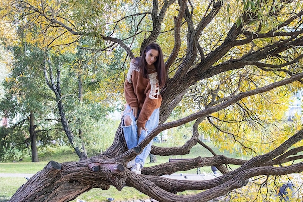 Une fille parseme sur une branche d'arbre