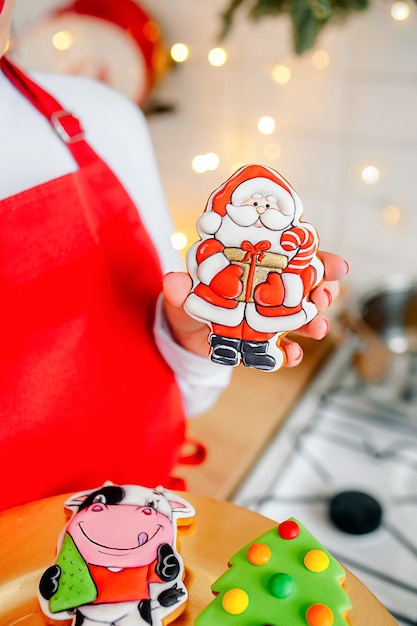 Fille pâtissière tenant des biscuits de Noël avec un décor festif