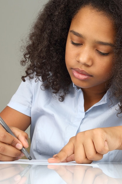 Photo fille à la peau sombre dessine un crayon sur papier