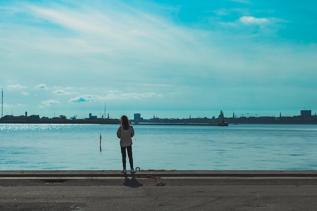 Fille pêchant dans le port de bord de mer