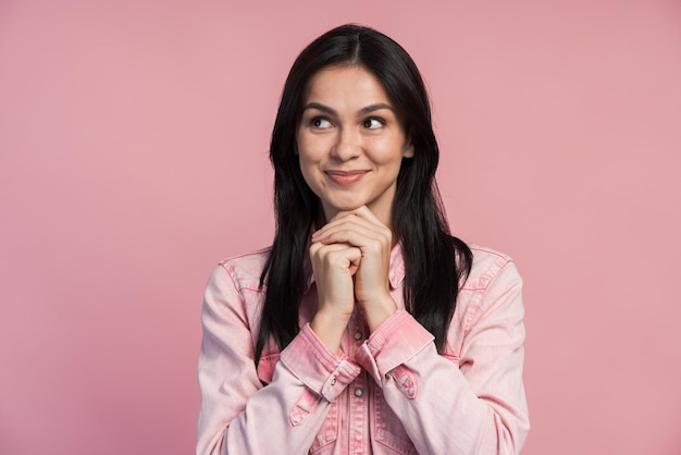 Fille pensante Portrait d'une femme sceptique drôle pensant en regardant le fond rose