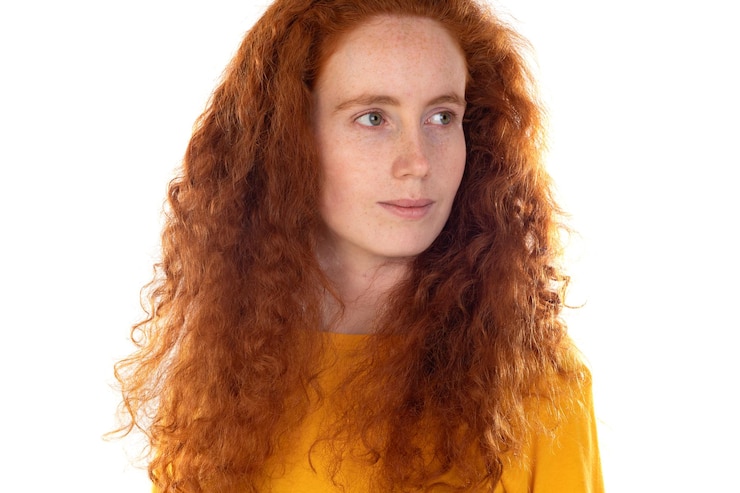 Photo fille pensive aux taches de rousseur aux cheveux roux portant un t-shirt orange