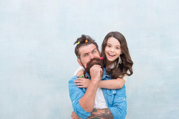 Fille et père avec coiffure drôle coiffeur et salon de coiffure bonne fête de la famille petite fille étreignant son père homme barbu père s'amusant avec enfant journée des enfants amour et confiance