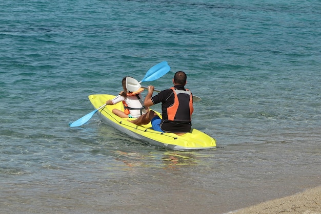 Fille et père explorant une baie tropicale calme en kayak Vue arrière