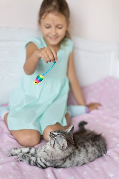 Fille avec petit chaton dans la chambre