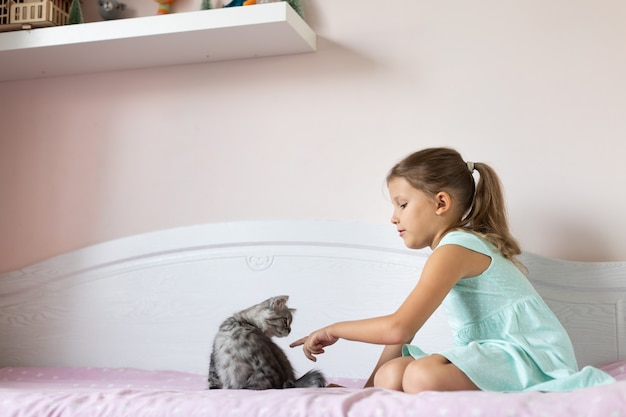 Fille avec petit chaton dans la chambre