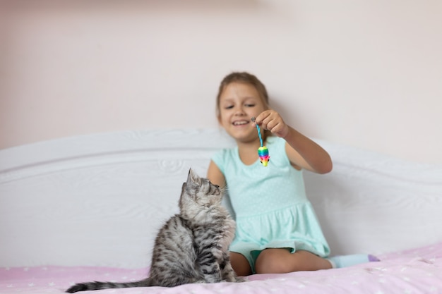 Fille avec petit chaton dans la chambre