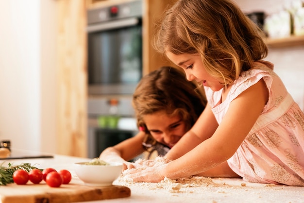 Fille de petites sœurs préparant des biscuits. Concept de chef infantile.