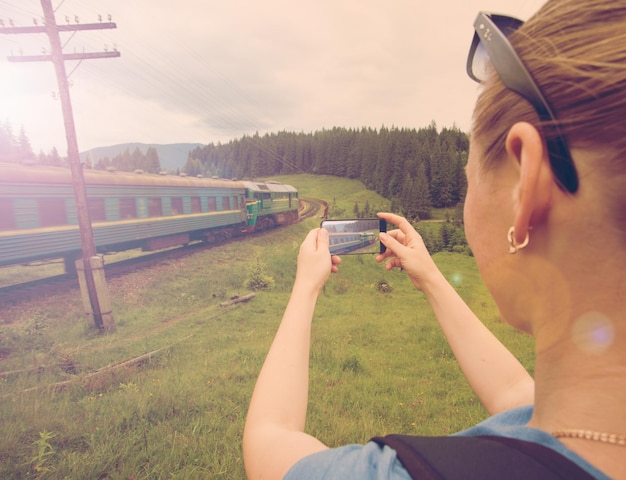 Fille photographiant le train qui passe