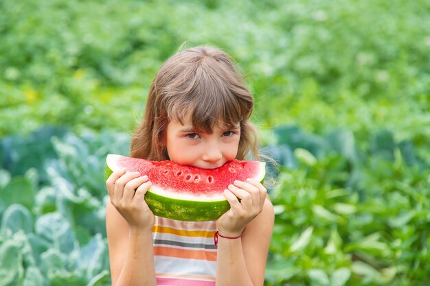 Fille sur un pique-nique mange une pastèque.