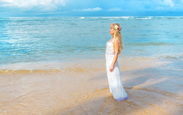 Fille sur la plage au bord de l'océan.