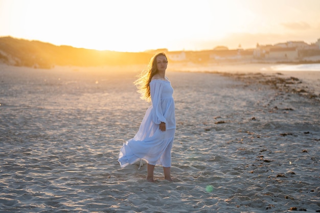 Fille sur la plage sur fond de soleil couchant. Concept : légèreté, légèreté