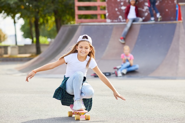 Fille sur planche à roulettes dans le parc