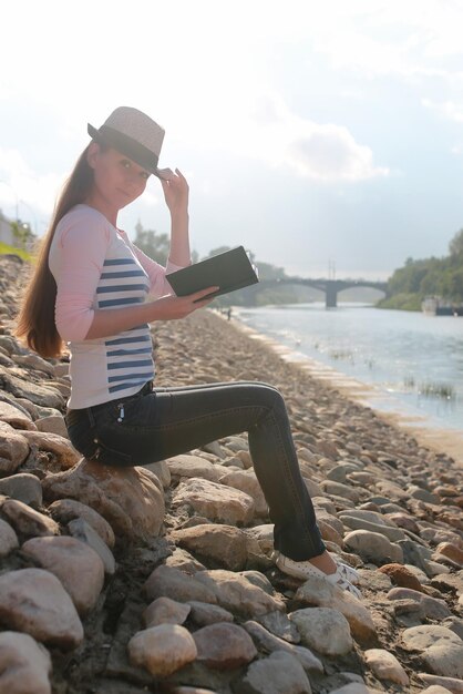 Fille en plein air lire livre stone river