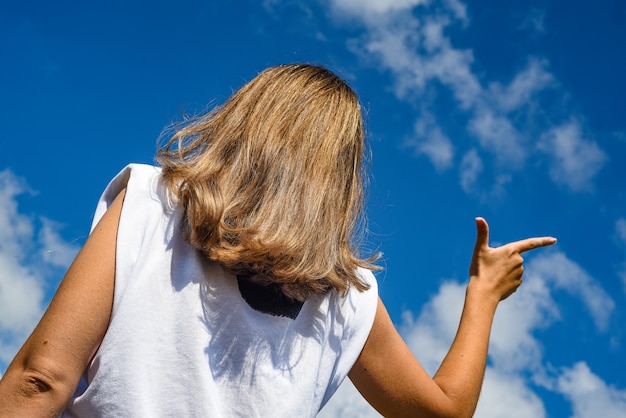 fille pointe un doigt contre le ciel.