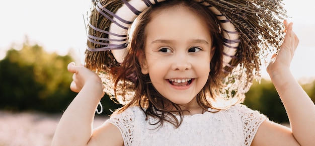 fille portant une couronne de fleurs en marchant dans un champ de lavande